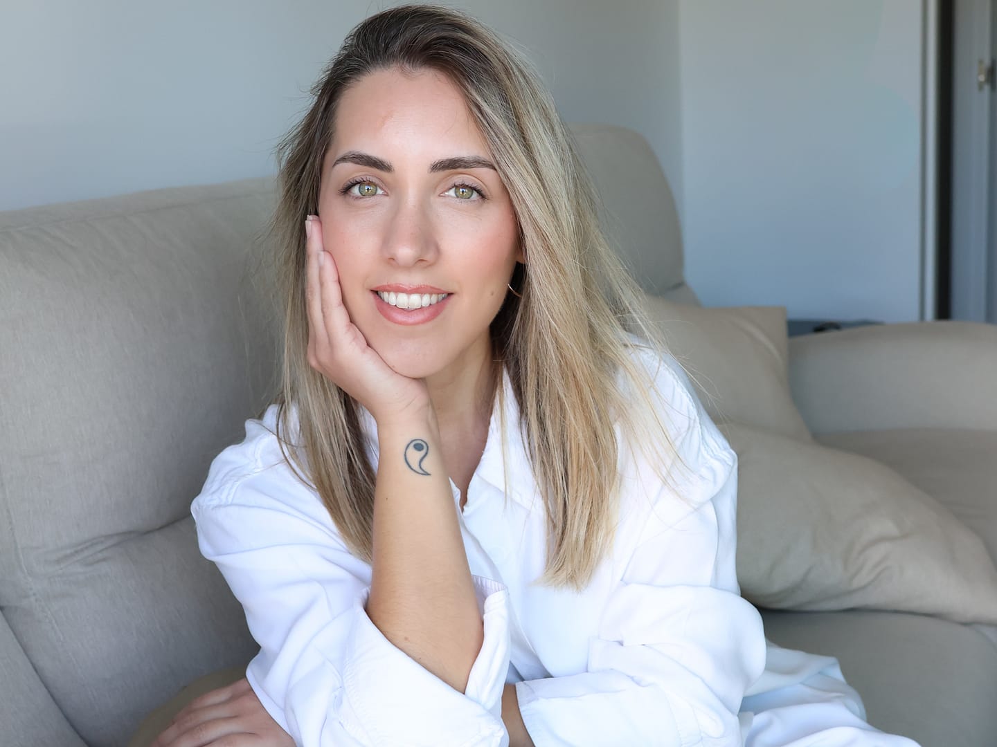 Sandra Pérez, psicóloga, sonriendo con camisa blanca